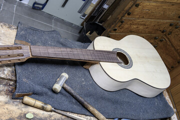 Handcrafted guitar with unfinished neck on workbench