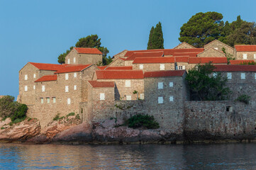 Sveti Stefan Island Hotel, stone houses of a medieval fortress village with tiled roofs on the Adriatic coast of Montenegro