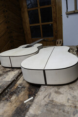 Two classical guitars under construction on a luthier's bench