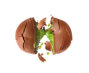 Cracked chocolate shell with green filling splashing out. Dubai chocolate is made with pistachio paste and kadayif