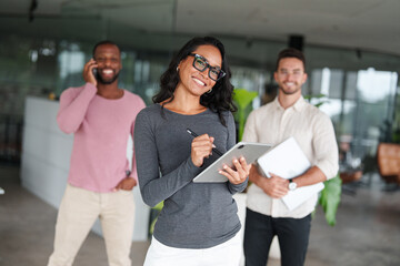Confident Multiracial Professionals Collaborating in a Modern Office with Bright Lighting and Green...