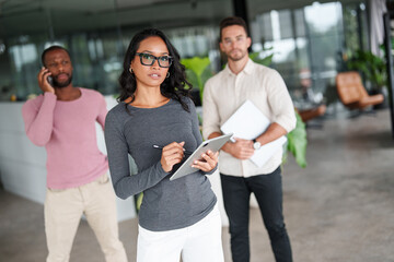 Multiracial Professional Team Working Together In Contemporary Corporate Office With Glass...