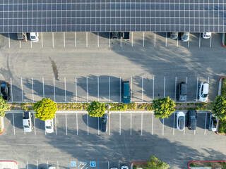 Aerial view of solar panels installed as shade roof over parking lot for parked cars. Photovoltaic technology integrated in urban infrastructure. High quality photo