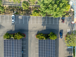 Aerial view of solar panels installed as shade roof over parking lot for parked cars. Photovoltaic technology integrated in urban infrastructure. High quality photo