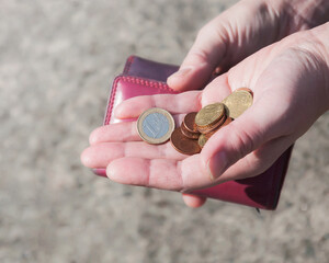 Pink purse and coins in female hands, selective focus.	