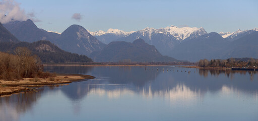 Winter scenery with snowy mountains and calm river