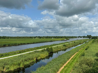 Typical Dutch canal with a partly cloudy sky.