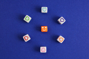 Cube with a happy face surrounded by colorful hearts