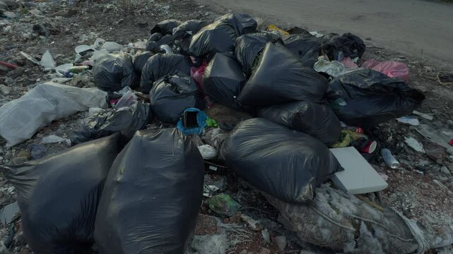 A significant accumulation of various types of trash and bags clearly indicating poor waste disposal practices
