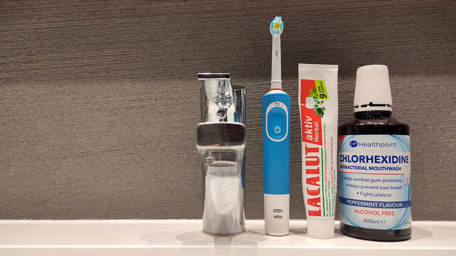 Warsaw, Poland - June 10, 2025: Electric toothbrush, toothpaste, mouthwash on bathroom sink with modern decor