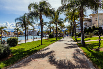 Beautiful park with tall palm trees on a sunny warm day in Gandia, Spain	
