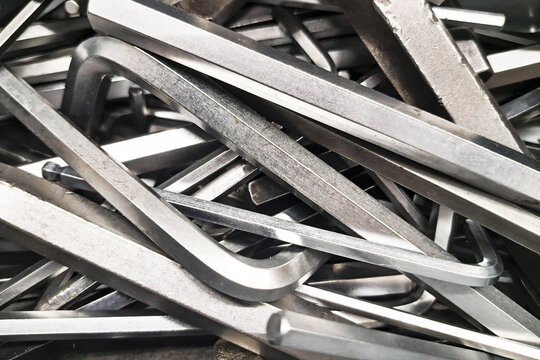 Metal hex keys in toolbox. Set of Allen wrenches scattered. Mechanical repair tools closeup. Industrial steel equipment. Workshop hardware collection.