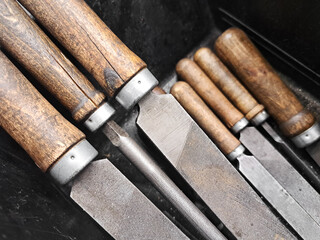 Vintage metal files with wooden handles. Old workshop hand tools. Manual carpentry equipment set. Rustic mechanic workspace. Sharp traditional blades in closeup.