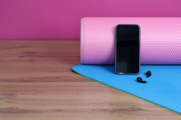 Essential Fitness Accessories A Yoga Mat, Phone, and Earbuds Set Against a Colorful Background