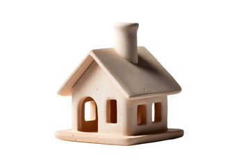 A small, decorative ceramic house model features a chimney and windows