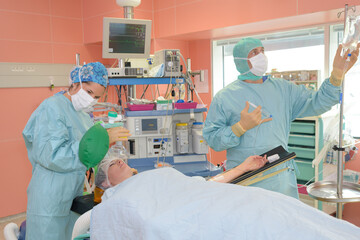 medical staff preparing for operation on woman in theatre