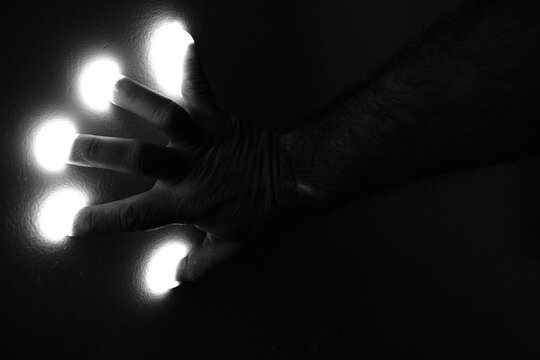 M&atilde;os e dedos de homem e luz. 