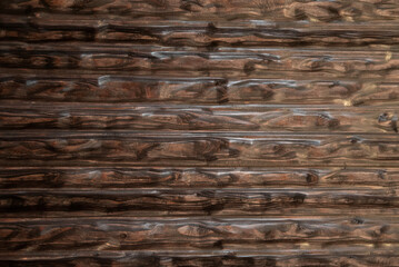Dark carved wood panel with deep horizontal ripple pattern