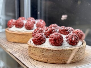 An assortment of Delicious Raspberry Tarts Beautifully Displayed in a Cozy Bakery. Delightful...