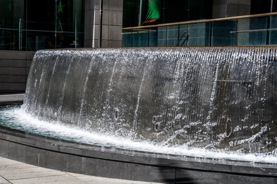 Waterfall water feature in an urban public space with water cascading over the curved rim_20101217_05175.