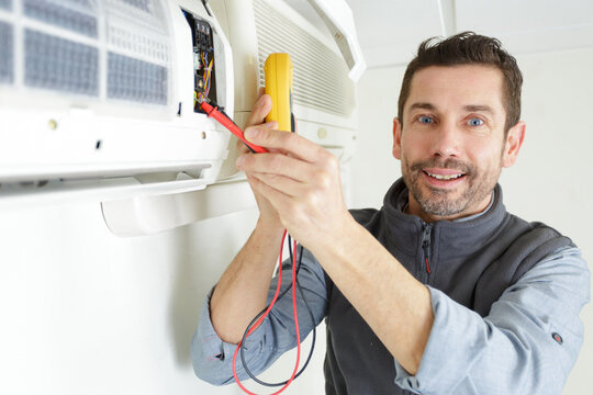 man inspecting an air conditionning machine - Powered by Adobe