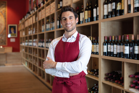 handsome sommelier standing smiling in a wine store
