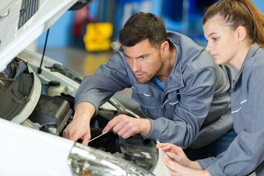 male and female mechanic team examine car engine