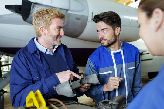team of workers assembling an aircraft - Powered by Adobe