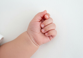 Tiny newborn baby hand closeup on white
