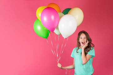 Birthday, party or celebration concept. Cute little european surprised young girl with huge group of colorful balloons on pink background
