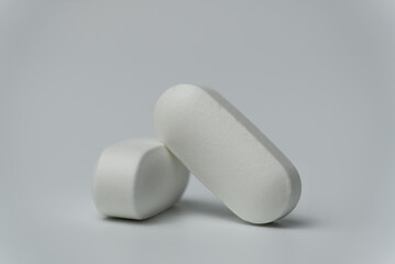 Close up macro shot of a two tablets pills on a light grey background