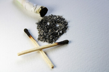 An extinguished cigarette and its ashes form a symbol of death