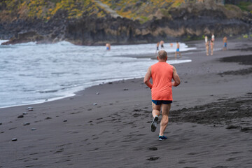 Man running on volcanic beach