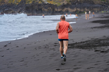 Man running on volcanic beach