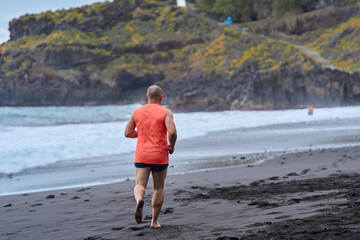 Man running on volcanic beach