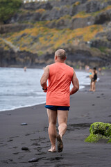 Man running on volcanic beach