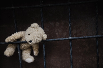 Concept: lost childhood, loneliness, pain and depression. Dirty teddy bear lying down outdoors.Copy...