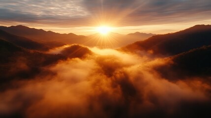 Fototapeta premium A breathtaking view of a sunrise over majestic mountains, with soft clouds and mist enveloping the landscape, creating an ethereal atmosphere that evokes awe and tranquility.
