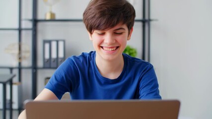 Cheerful teen interacting and giving thumbs up in modern home office setting