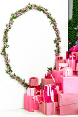 Decorative pink gifts surrounded by floral arrangement in a festive corner