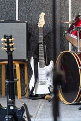 Band setup with electric guitar and drums on stage during music rehearsal in daylight hours