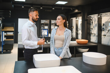 Woman looking for sink at house of ceramics and plumbing materials