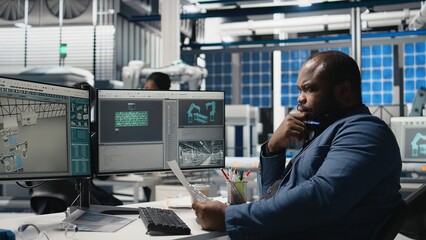 Industrial operations expert checking performance data in a solar panel factory, showcasing dedication to workplace efficiency and working on green energy manufacturing and engineering. Camera A.