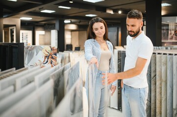 Young couple choosing tiles at building market