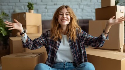 Happy young woman sitting among cardboard boxes with arms open, celebrating moving into a new home, symbolizing relocation, new beginnings, and excitement for the future