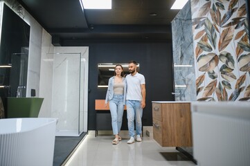 Young family couple choosing bathroom sink in bathroom fixtures store