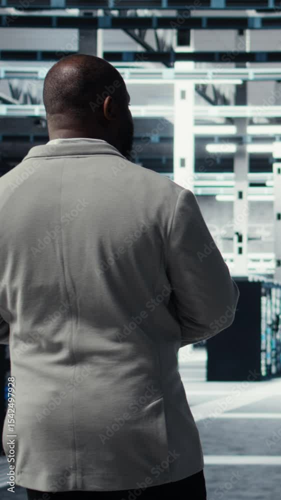 Poster vertical video technician walking in data center workplace with multiple rows of fully operational m