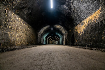 Long dark tunnel with lights disappearing into the distance