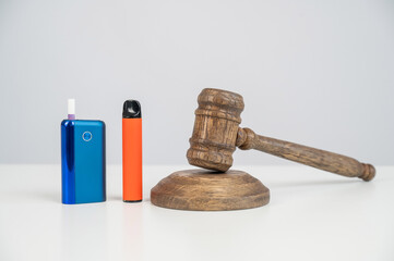 Judge's gavel, disposable vape and electronic cigarette. Smoking ban. Tobacco heating systems.