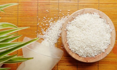 Raw grains rice in wooden bowl decorated in rustic style on wooden background. Illustration of rice...